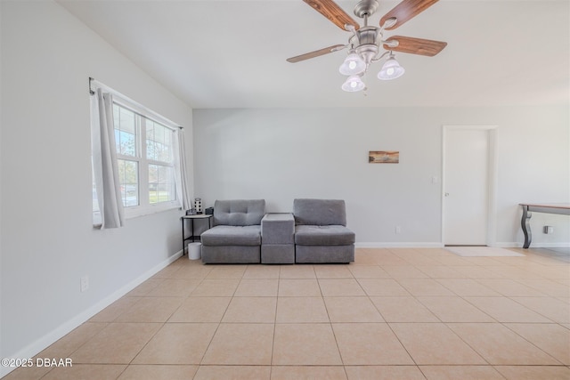 living room featuring ceiling fan, baseboards, and light tile patterned floors