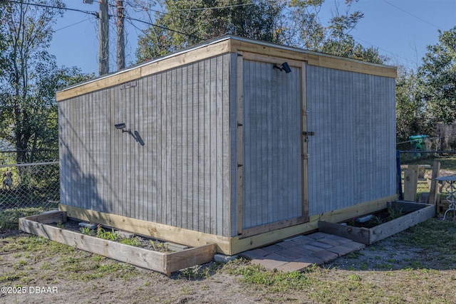 view of shed featuring fence and a garden