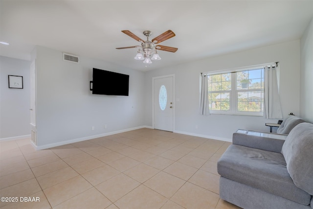 living area with visible vents, ceiling fan, baseboards, and light tile patterned flooring