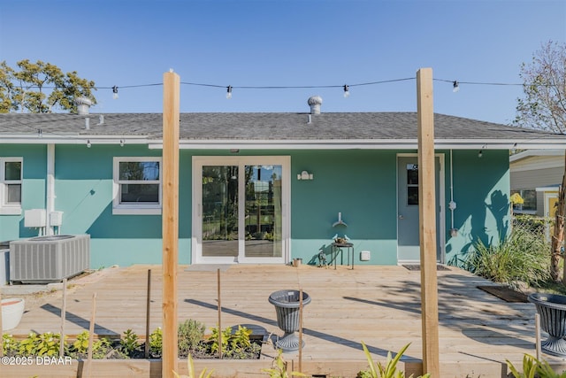 back of house featuring a shingled roof, stucco siding, a wooden deck, and central air condition unit