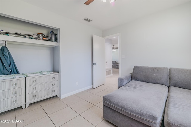 interior space featuring light tile patterned floors, a ceiling fan, visible vents, and baseboards