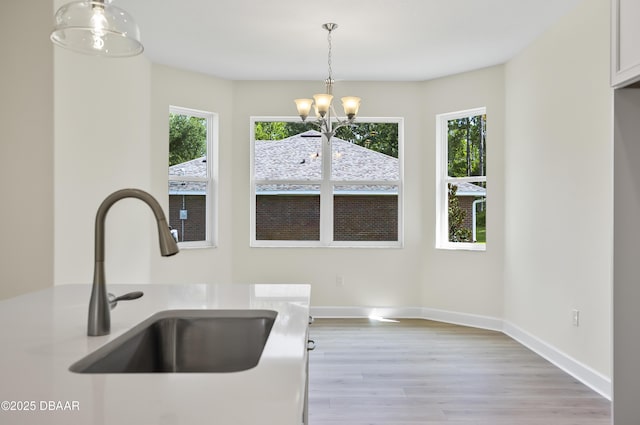 kitchen featuring sink, pendant lighting, plenty of natural light, and a notable chandelier