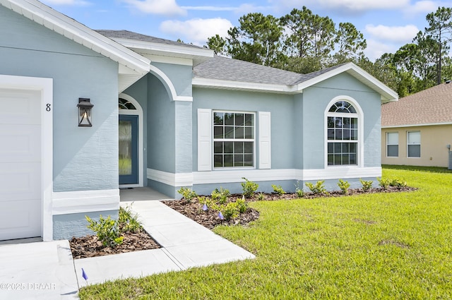 view of exterior entry with a yard