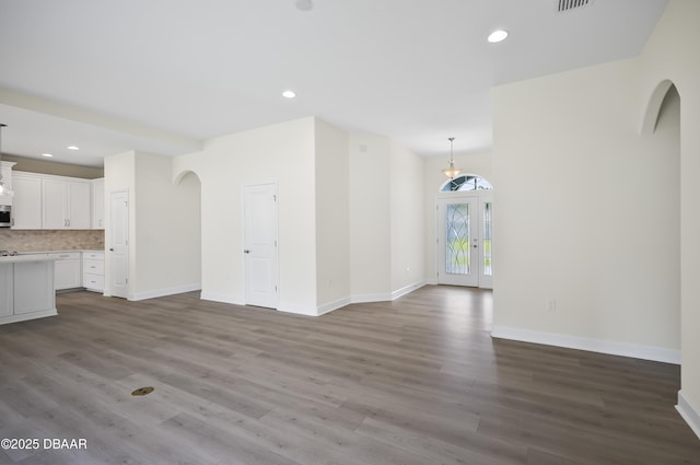 unfurnished living room with wood-type flooring and french doors