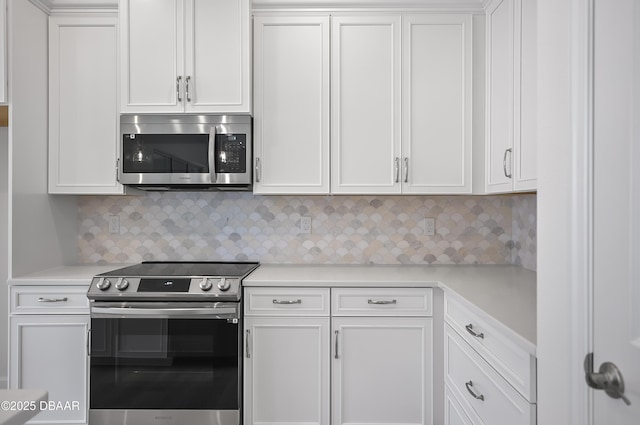 kitchen featuring tasteful backsplash, appliances with stainless steel finishes, and white cabinetry