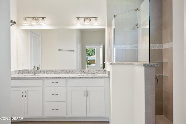 bathroom with vanity and a tile shower