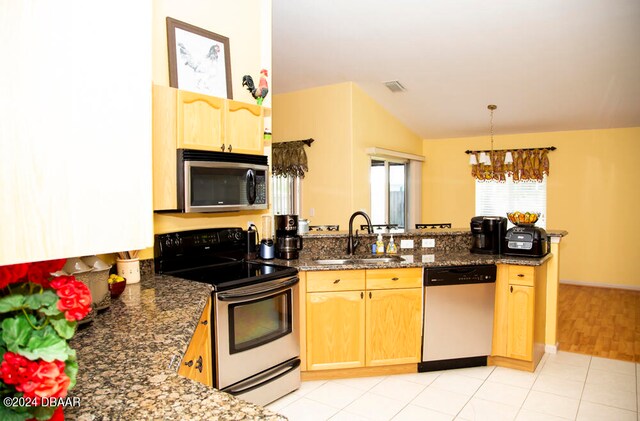 kitchen with sink, appliances with stainless steel finishes, dark stone countertops, decorative light fixtures, and a notable chandelier