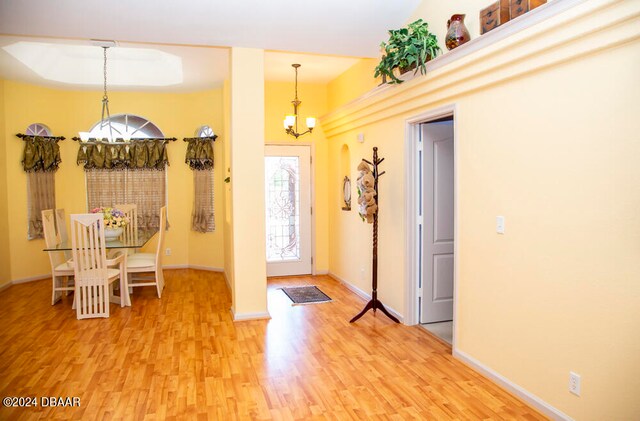 foyer with wood-type flooring and a notable chandelier