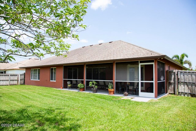 back of house with a lawn and a sunroom