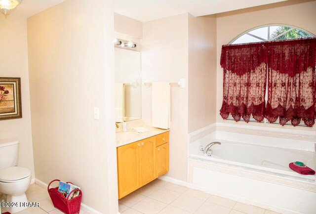 bathroom featuring a bath, vanity, tile patterned floors, and toilet