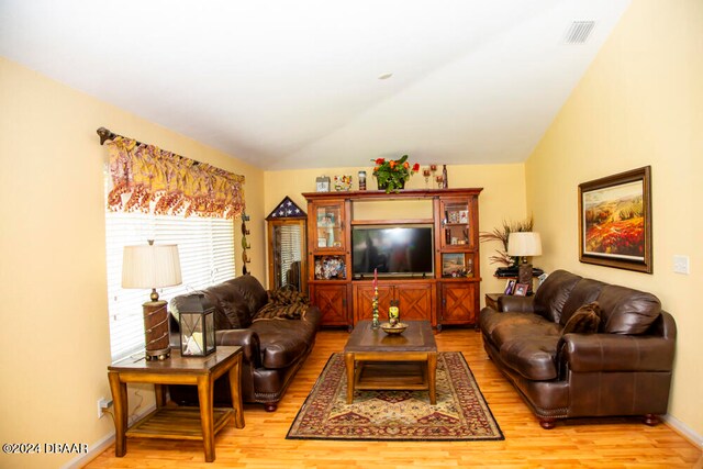 living room featuring wood-type flooring and lofted ceiling