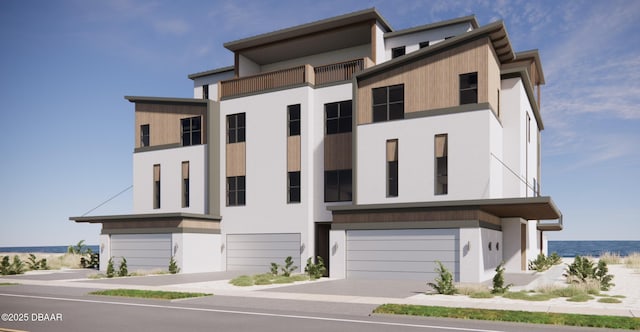 3403 S Atlantic Ave Unit 2, New Smyrna Beach, FL 32169 - view of front of house with stucco siding, concrete driveway, a water view, and a garage