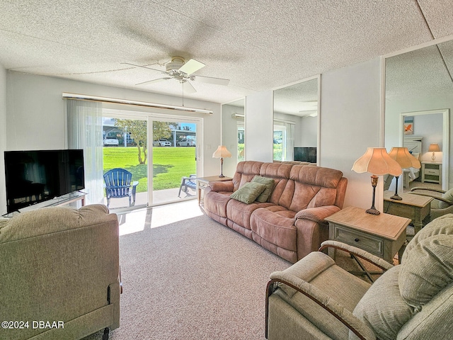 carpeted living room featuring ceiling fan and a textured ceiling