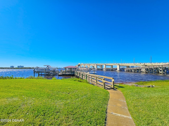 dock area with a water view and a yard