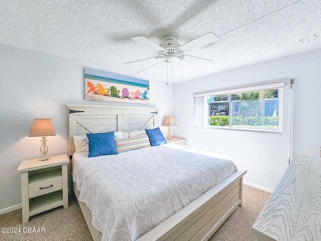 carpeted bedroom with ceiling fan and a textured ceiling