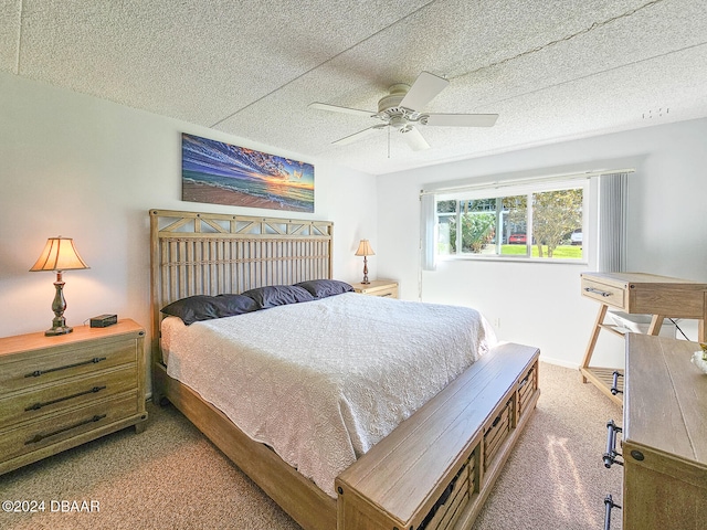 bedroom featuring ceiling fan, carpet floors, and a textured ceiling