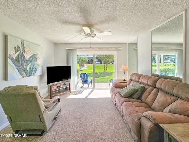 carpeted living room with a textured ceiling, plenty of natural light, and ceiling fan