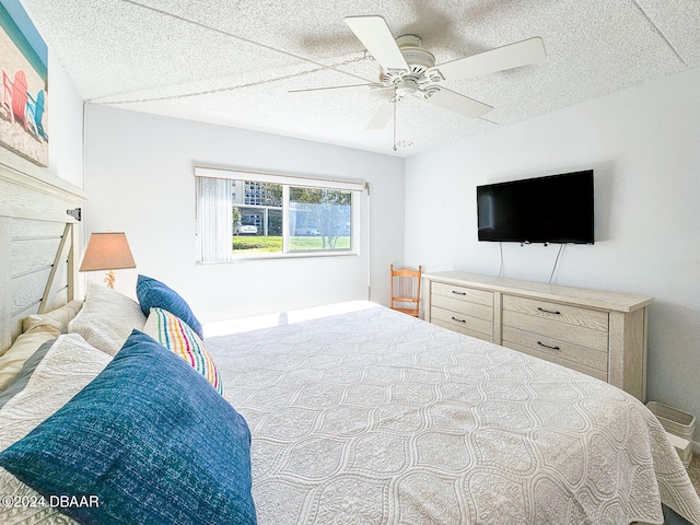 bedroom with ceiling fan and a textured ceiling