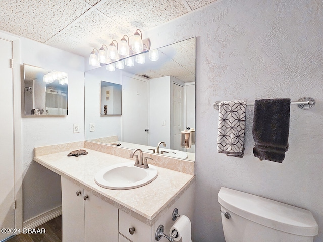 bathroom featuring a paneled ceiling, vanity, and toilet