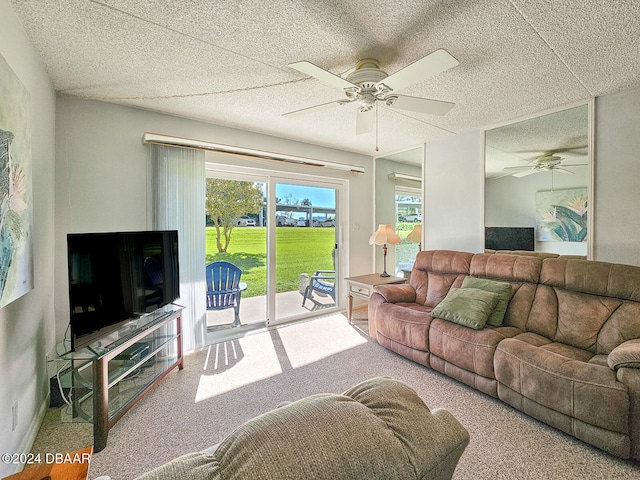 living room with ceiling fan, carpet floors, and a textured ceiling