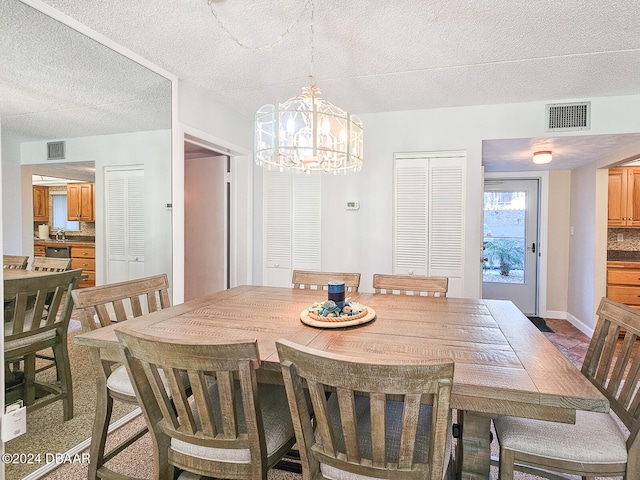 dining area with a chandelier and a textured ceiling