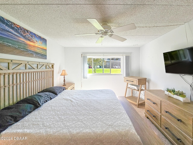 bedroom featuring ceiling fan, a textured ceiling, and light hardwood / wood-style flooring