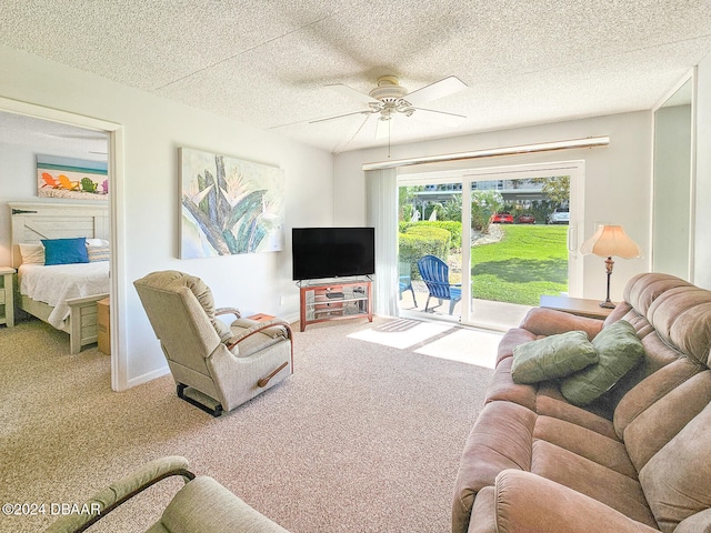 carpeted living room featuring ceiling fan and a textured ceiling