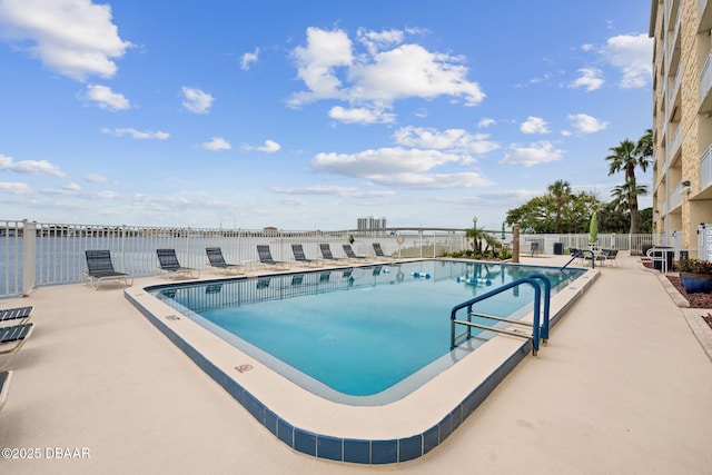 view of pool with a water view and a patio area