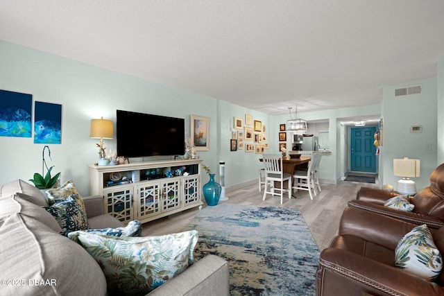 living room featuring a textured ceiling and light wood-type flooring