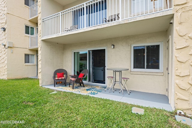 back of house featuring a balcony and a lawn