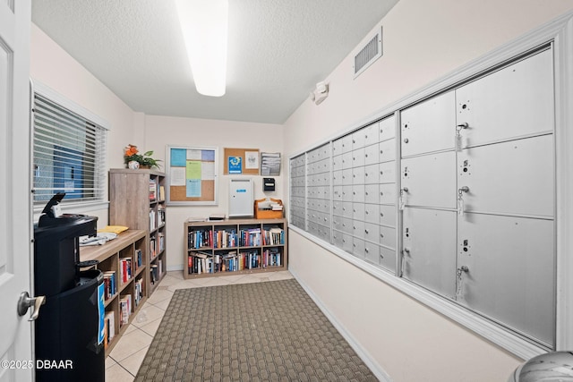 office space featuring light tile patterned floors, mail boxes, and a textured ceiling