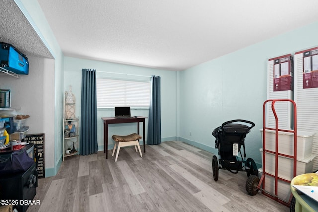 office with a textured ceiling and light wood-type flooring