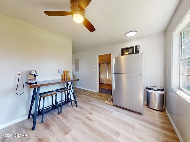 903 Conrad Dr, New Smyrna Beach, FL 32168 - kitchen with freestanding refrigerator, black microwave, light wood-style flooring, and healthy amount of natural light