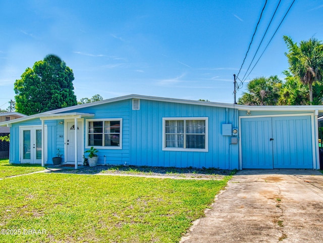 903 Conrad Dr, New Smyrna Beach, FL 32168 - view of front facade featuring french doors, a front yard, concrete driveway, and board and batten siding