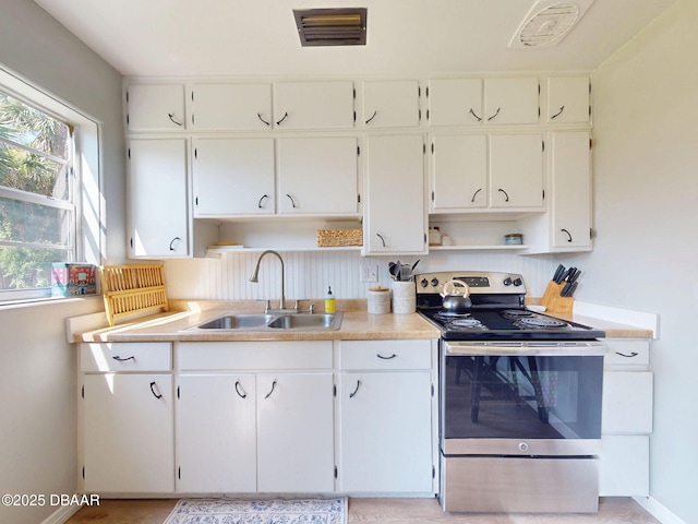 903 Conrad Dr, New Smyrna Beach, FL 32168 - kitchen featuring stainless steel electric range oven, open shelves, white cabinets, and light countertops