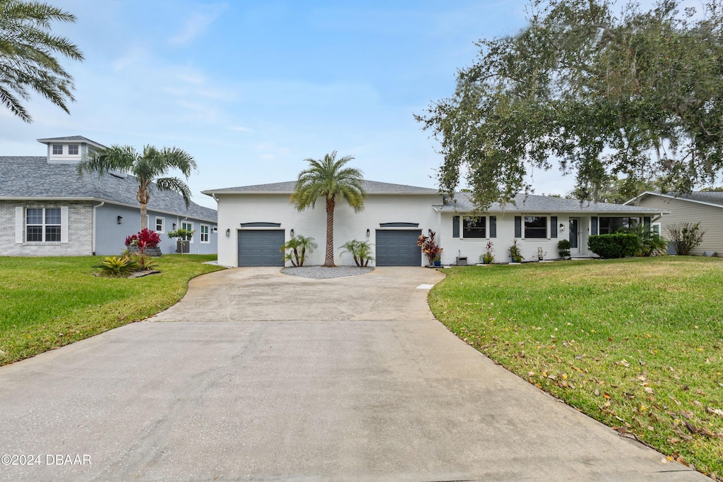 ranch-style home featuring a garage and a front lawn