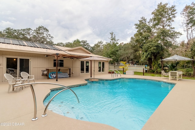 view of swimming pool with ceiling fan and a patio area