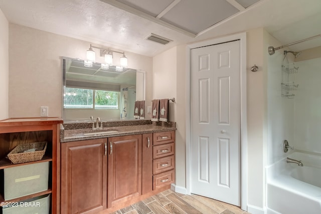 bathroom featuring shower / bath combination, vanity, hardwood / wood-style floors, and a textured ceiling