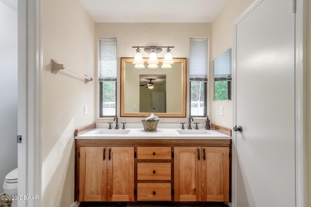 bathroom featuring plenty of natural light, vanity, ceiling fan, and toilet