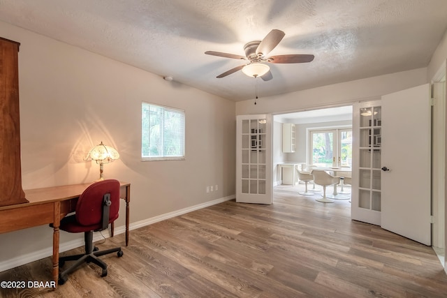 unfurnished office with hardwood / wood-style flooring, ceiling fan, a textured ceiling, and french doors