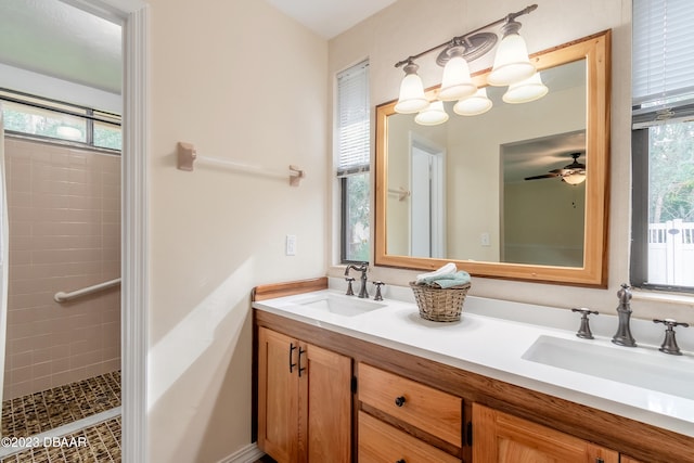 bathroom featuring vanity, ceiling fan, plenty of natural light, and tiled shower