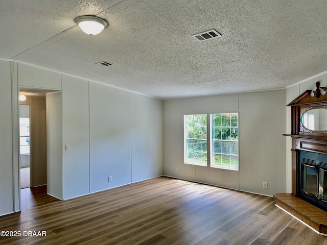 1910 Woodcrest Dr, Ormond Beach, FL 32174 - unfurnished living room featuring wood finished floors, a textured ceiling, and a glass covered fireplace