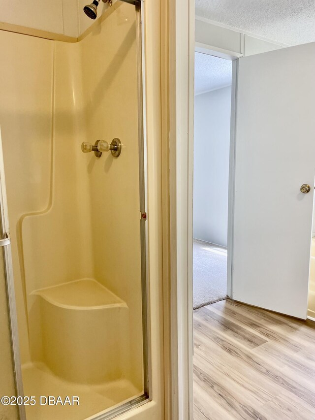1910 Woodcrest Dr, Ormond Beach, FL 32174 - full bath featuring a stall shower, a textured ceiling, and wood finished floors