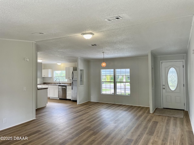1910 Woodcrest Dr, Ormond Beach, FL 32174 - entryway with a textured ceiling, dark wood-style flooring, and ornamental molding
