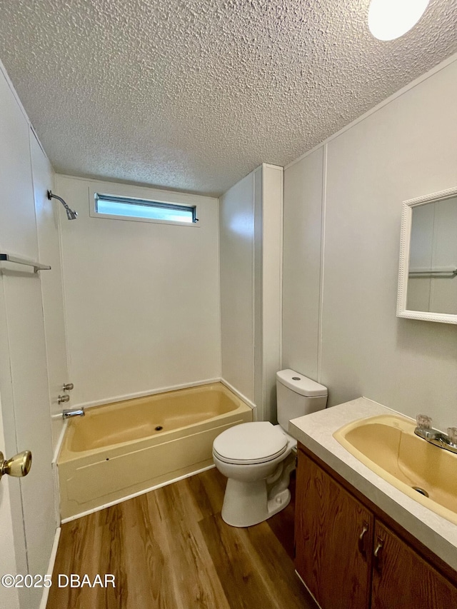 1910 Woodcrest Dr, Ormond Beach, FL 32174 - full bathroom with a textured ceiling, wood finished floors, vanity, toilet, and bathtub / shower combination