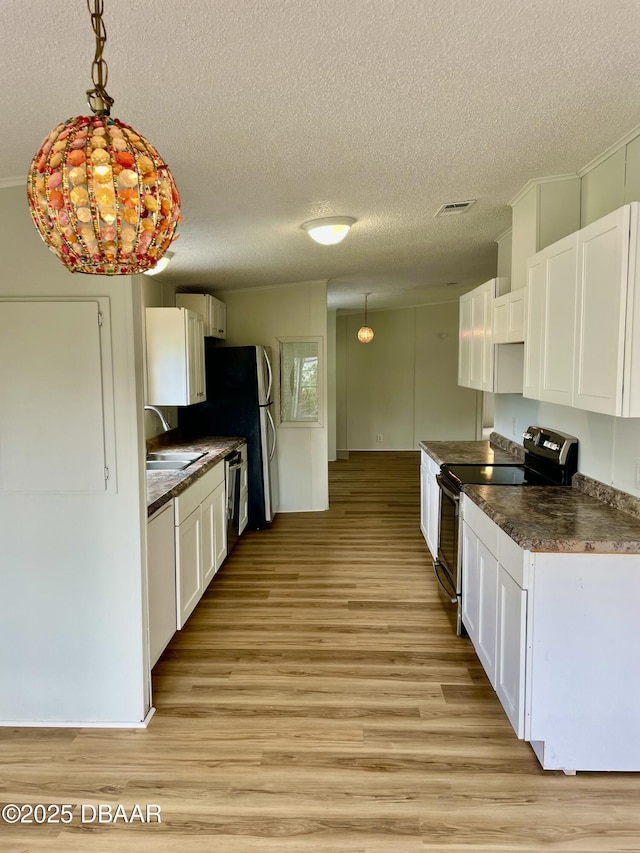 1910 Woodcrest Dr, Ormond Beach, FL 32174 - kitchen with electric range, dark countertops, a sink, white cabinets, and a textured ceiling