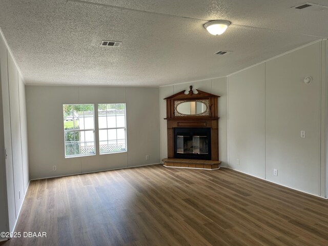 1910 Woodcrest Dr, Ormond Beach, FL 32174 - unfurnished living room featuring a textured ceiling, wood finished floors, a glass covered fireplace, and a decorative wall