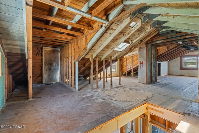 unfinished attic featuring a skylight