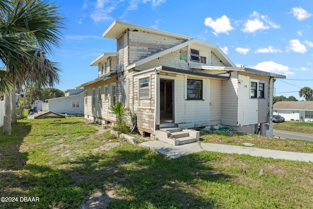 back of house with a lawn