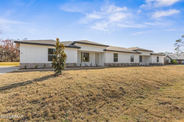 21 Weymouth Ln, Palm Coast, FL 32164 - prairie-style home featuring stucco siding, a front yard, and stone siding